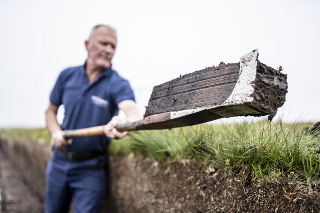 Close up peat being cut traditionally by hand at the peat bank